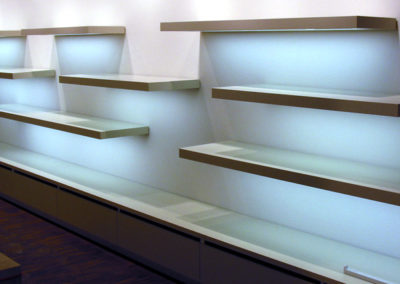 Verkaufsladen-Regal mit "freischwebenden" Tablaren über einer eingebauten Lichtquelle.